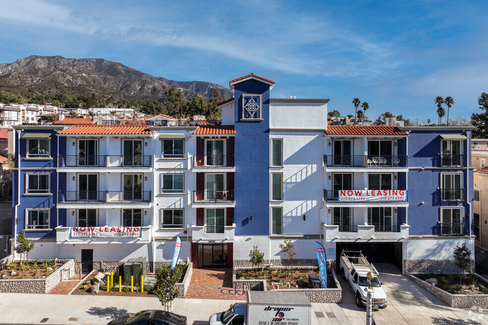 Commerce Villas exterior at twilight with the San Gabriel Mountains in the background